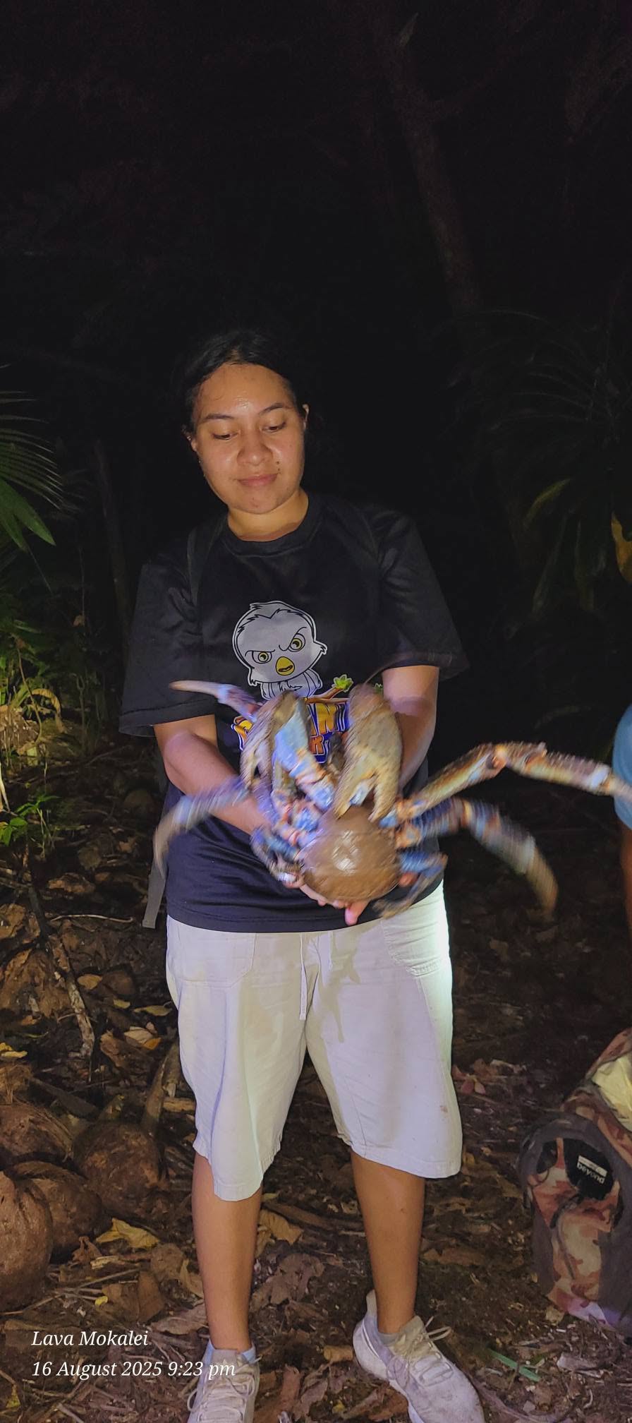 Taue Uga Tours guest holding a large uga in Niue's forest